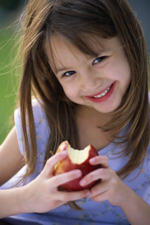 ca. 2002 --- Girl Eating Apple --- Image by © Royalty-Free/Corbis